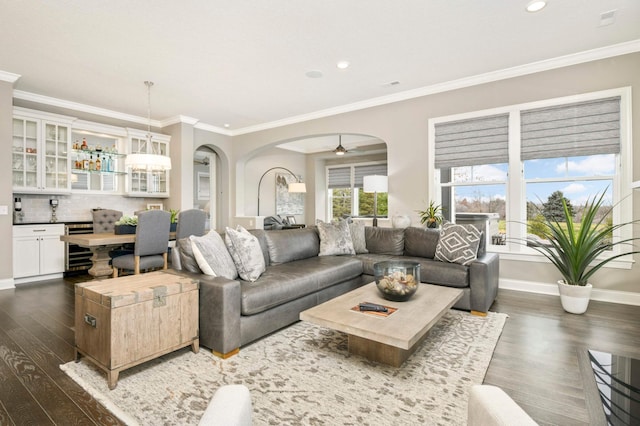 living room with ornamental molding, dark hardwood / wood-style floors, ceiling fan, and beverage cooler