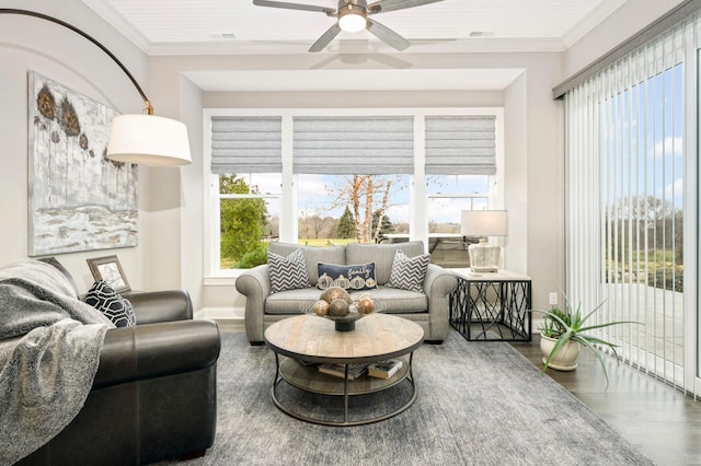 living room featuring hardwood / wood-style flooring, a wealth of natural light, crown molding, and ceiling fan