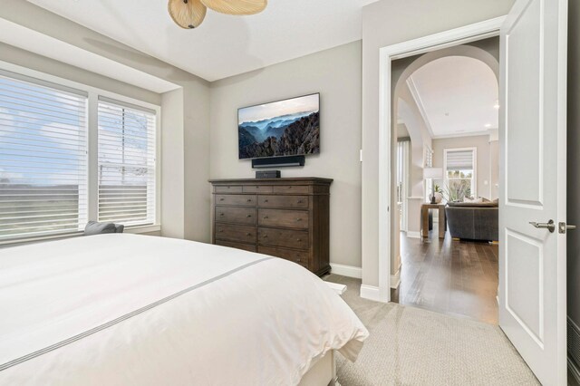 bedroom with hardwood / wood-style flooring, multiple windows, and ceiling fan