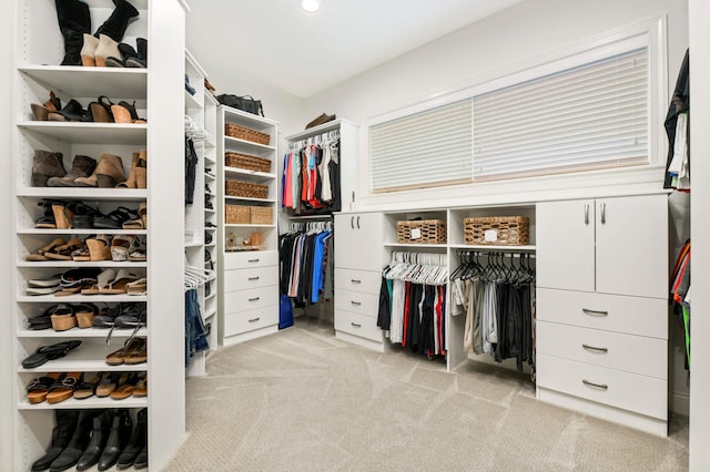 walk in closet featuring light carpet