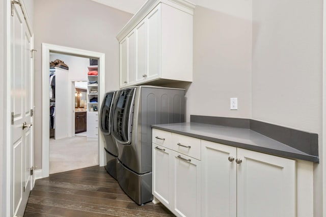 clothes washing area with cabinets, independent washer and dryer, and dark wood-type flooring