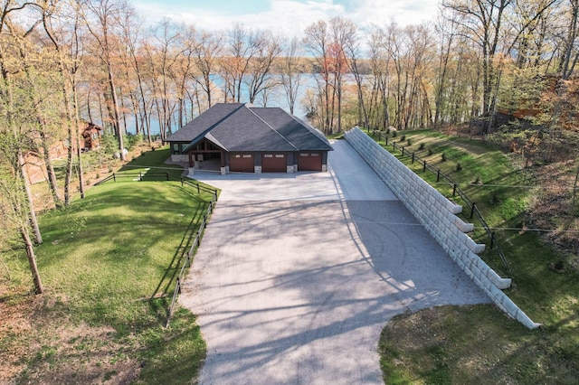 exterior space with driveway, a shingled roof, a front yard, and fence