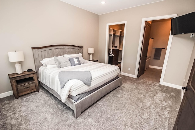 carpeted bedroom featuring a walk in closet, ensuite bathroom, and a closet