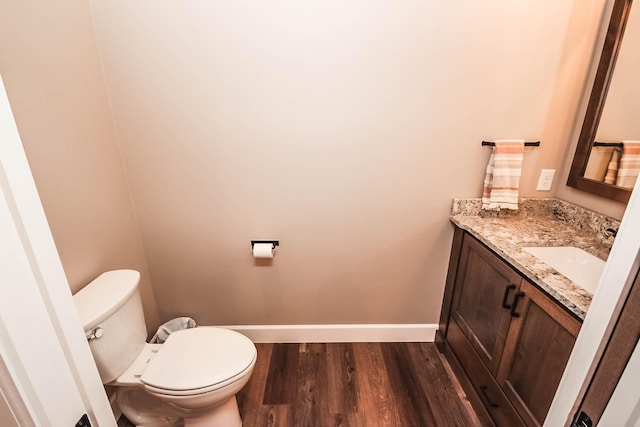 bathroom featuring wood-type flooring, vanity, and toilet