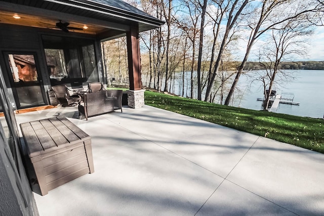 view of patio featuring ceiling fan, a water view, and an outdoor living space