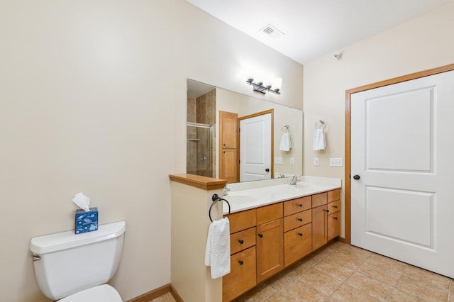 bathroom with tile patterned flooring, toilet, vanity, and walk in shower