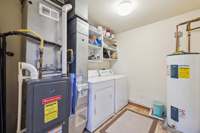 clothes washing area featuring laundry area, baseboards, washer and dryer, a textured ceiling, and water heater