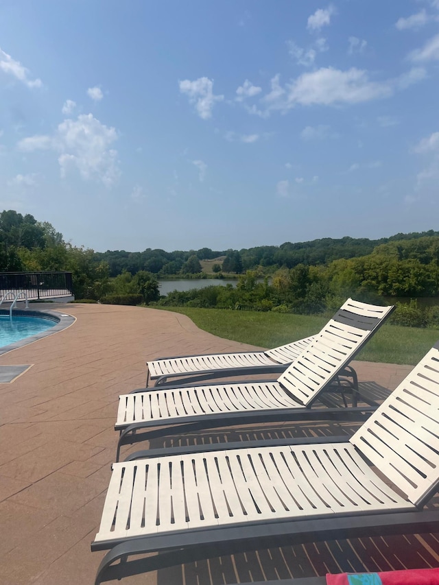 view of community featuring a water view, a view of trees, and a swimming pool