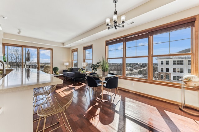 dining area with dark wood-style floors, visible vents, baseboards, and an inviting chandelier