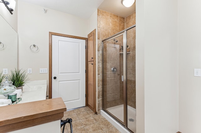 bathroom with tile patterned flooring, a shower stall, and vanity