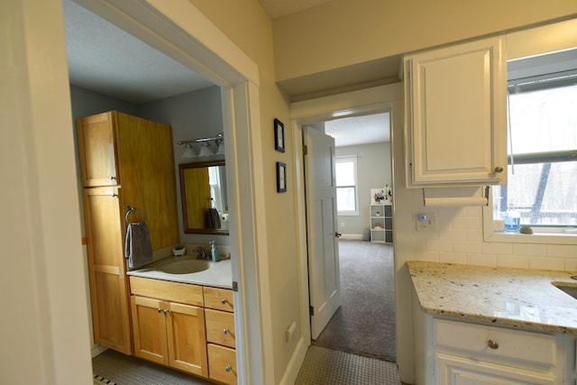 bathroom featuring vanity, tile patterned floors, and tasteful backsplash