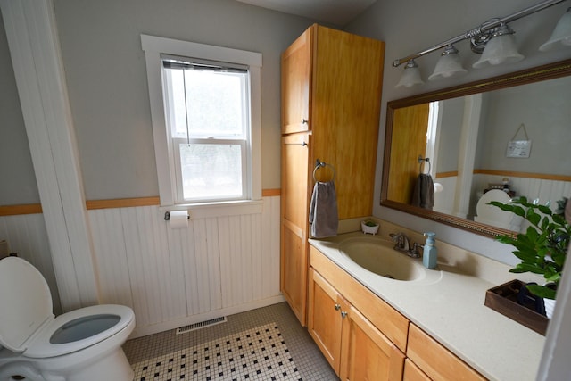 bathroom featuring toilet, tile patterned flooring, a wealth of natural light, and vanity