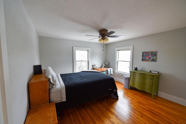 bedroom featuring hardwood / wood-style flooring, a textured ceiling, and ceiling fan