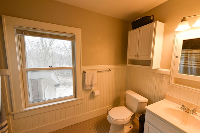 bathroom featuring vanity, toilet, wood walls, and tile patterned flooring