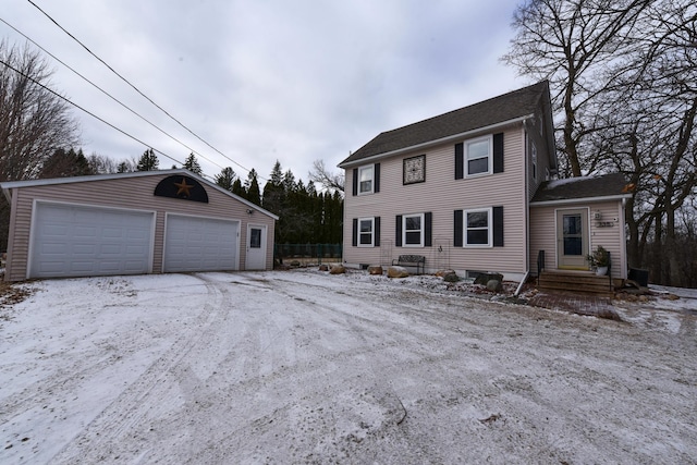 colonial-style house with a garage and an outbuilding