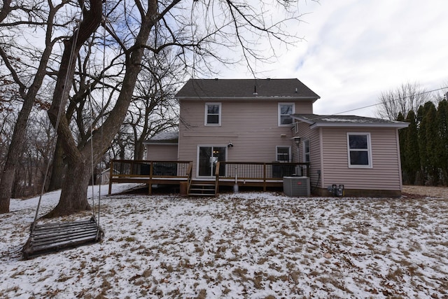 snow covered rear of property featuring cooling unit and a deck