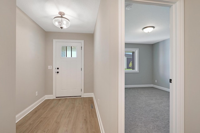 doorway featuring a textured ceiling and light hardwood / wood-style flooring