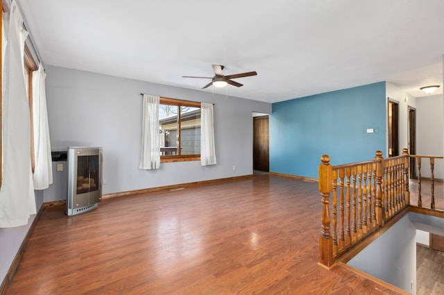 living room featuring dark hardwood / wood-style floors, heating unit, and ceiling fan