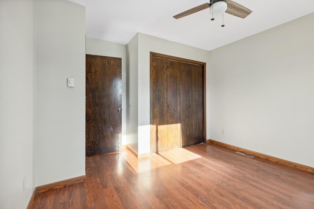 unfurnished bedroom featuring ceiling fan, wood-type flooring, and a closet