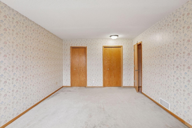 carpeted spare room with a textured ceiling