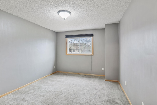 empty room featuring carpet and a textured ceiling