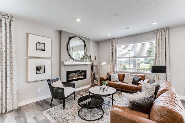 living room with a textured ceiling and light hardwood / wood-style flooring