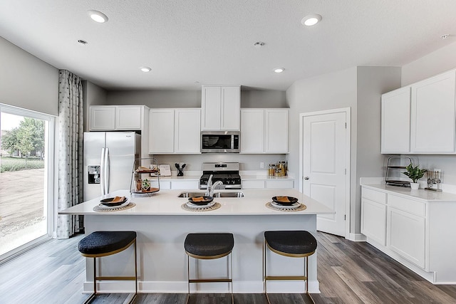 kitchen with a center island with sink, white cabinets, and appliances with stainless steel finishes