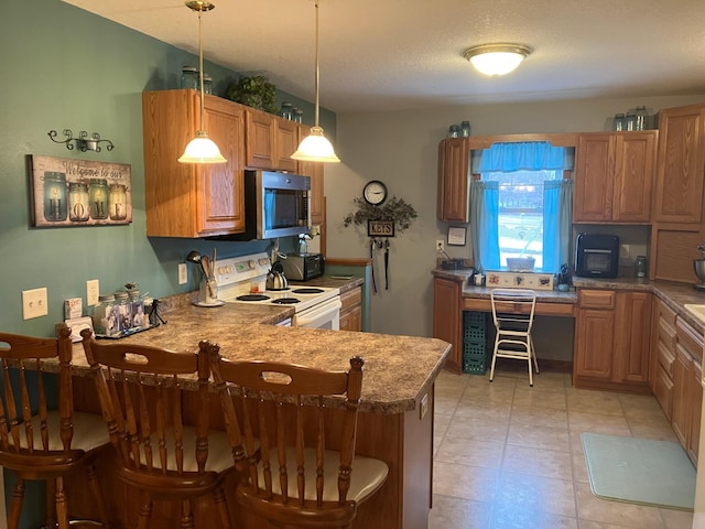 kitchen featuring kitchen peninsula, pendant lighting, a breakfast bar, and white electric stove