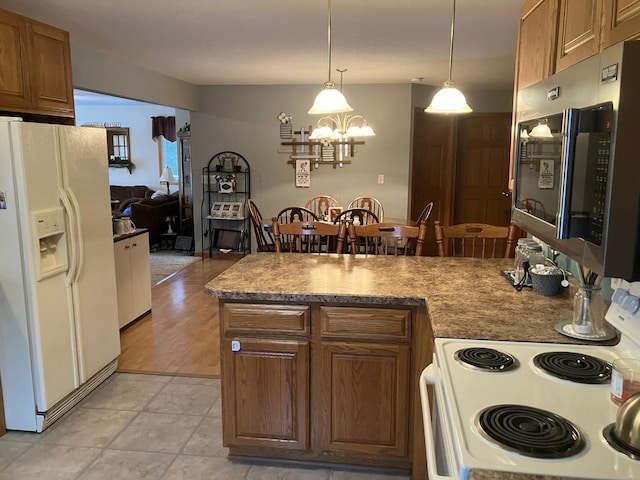 kitchen featuring light wood-type flooring, white appliances, hanging light fixtures, and a chandelier