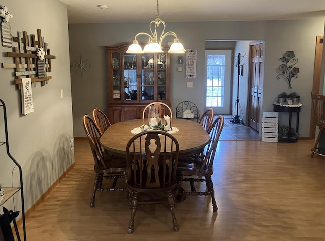 dining area featuring dark wood-type flooring and an inviting chandelier