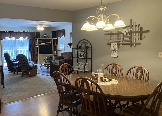 dining space featuring ceiling fan with notable chandelier and hardwood / wood-style flooring