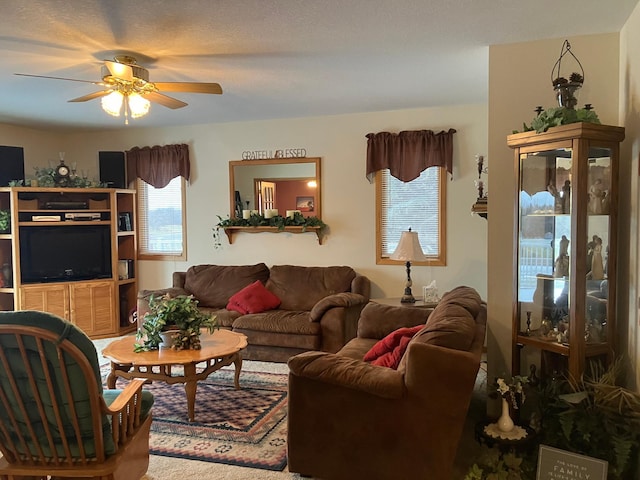 living room with a textured ceiling and ceiling fan