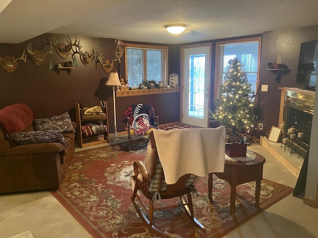 sitting room with a textured ceiling, a fireplace, and carpet