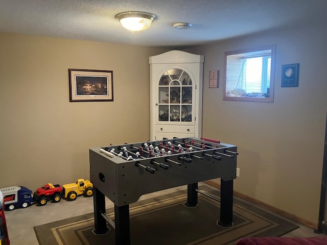 playroom with carpet and a textured ceiling