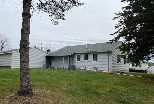 rear view of house with a lawn and central air condition unit