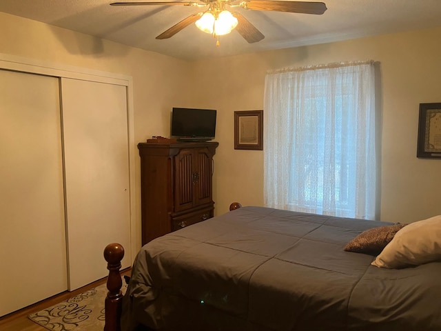 bedroom with hardwood / wood-style floors, ceiling fan, and a closet