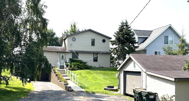 view of front facade featuring a garage, an outdoor structure, and a front yard