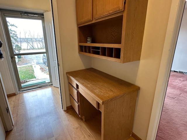 interior space featuring built in desk and light wood-type flooring