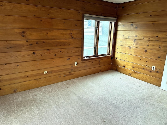 unfurnished room featuring wooden walls and carpet