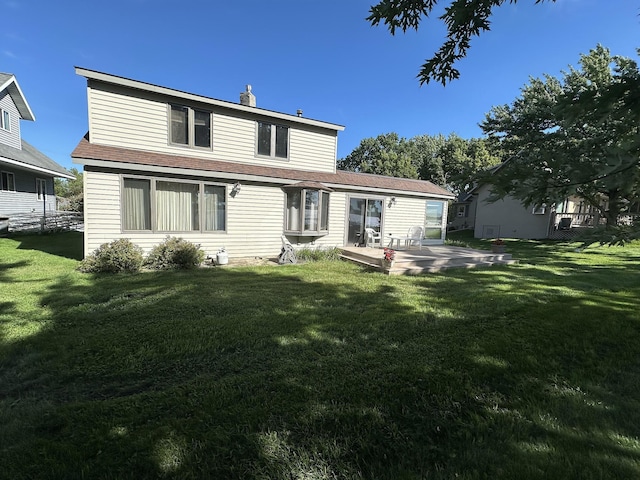back of property featuring roof with shingles, a yard, and a patio area