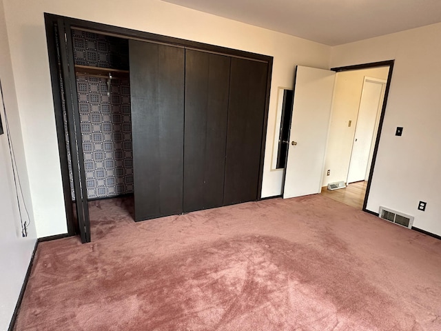 unfurnished bedroom with a closet, visible vents, and carpet floors