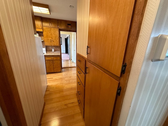 hall featuring wallpapered walls and light wood-style flooring