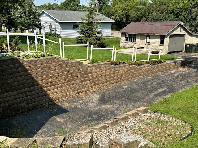 exterior space featuring a garage, fence, and a front yard