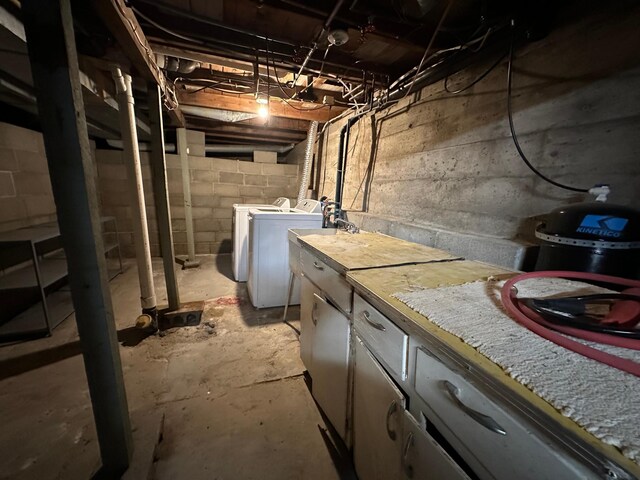 unfinished below grade area with washer and clothes dryer