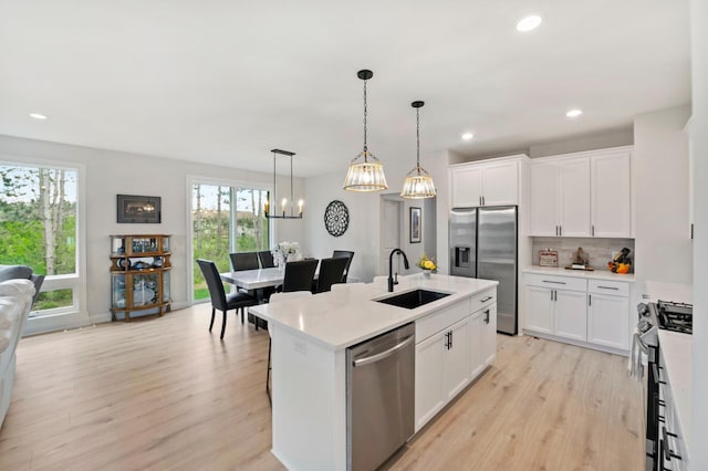 kitchen featuring appliances with stainless steel finishes, an island with sink, a wealth of natural light, and sink