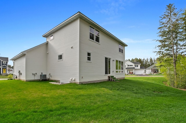 back of property with a yard and central air condition unit