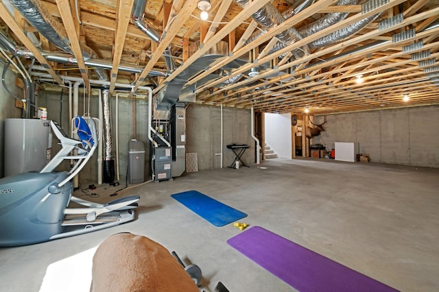 exercise room featuring heating unit and water heater