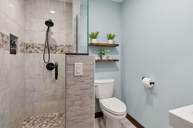 bathroom with toilet and tiled shower