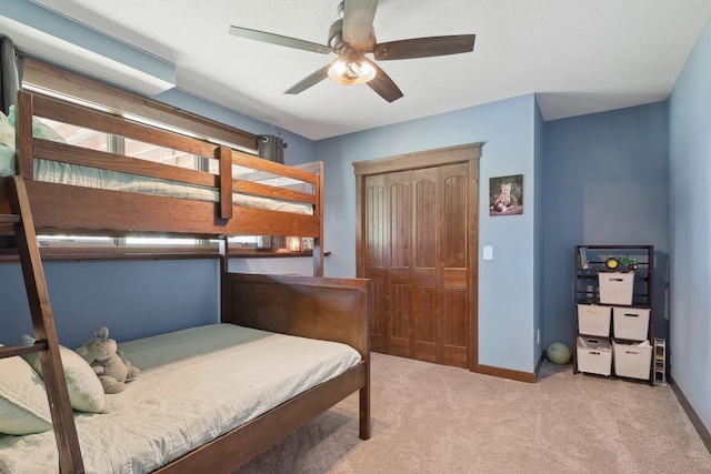 carpeted bedroom with a closet and ceiling fan