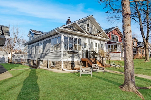 rear view of property featuring a lawn